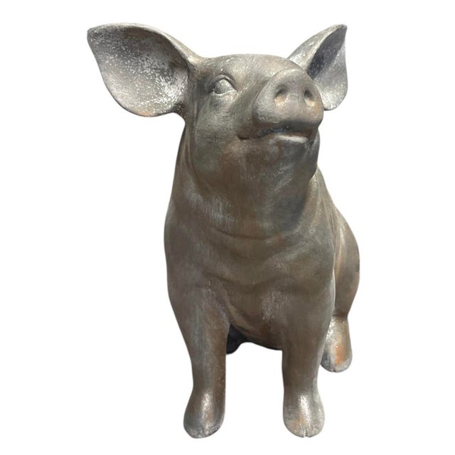 A charming and substantial vintage cast iron garden statue depicting a sitting pig. Expertly crafted with an eye for both...
