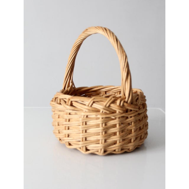 This vintage wicker gathering basket features a softly rounded form, woven handle, and warm honey-colored finish. Equally...