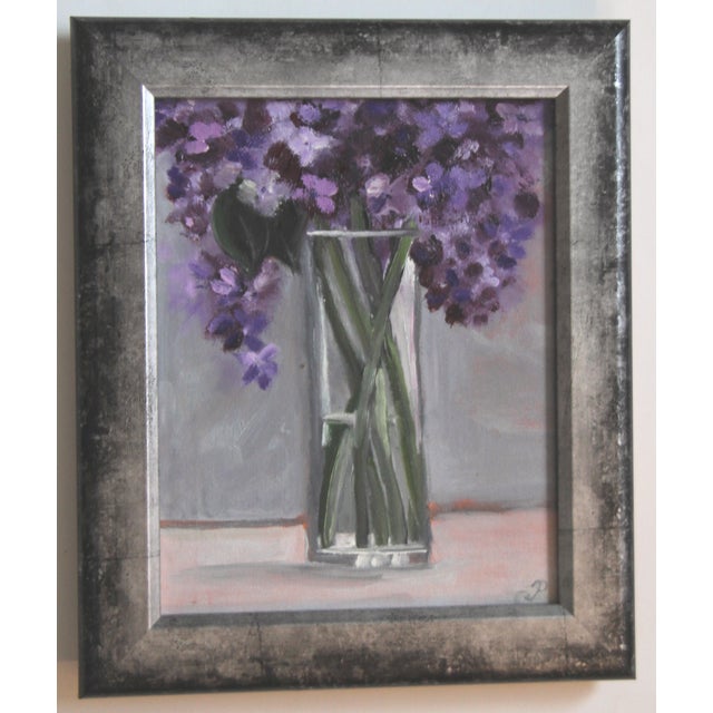 Oil painting of a vase of Lilacs painted in a textured impressionist style on a gray interior background, and framed in a...