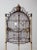 This is a 20th century French Victorian style birdcage. The monumental black iron dome cage features a golden tripod base...