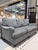 A tailored Bassett sofa upholstered in soft grey linen, offering a clean and inviting silhouette with timeless appeal. The...
