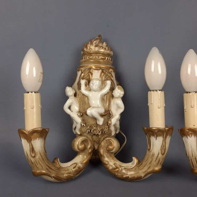 A stunning pair of vintage wall sconces, featuring finely detailed workmanship and a rich baroque-style gold patina. Each...