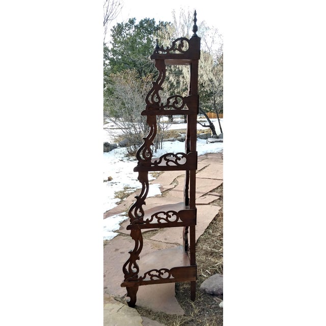 3-sided wooden corner whatnot with elaborate decorative walls on 2 sides