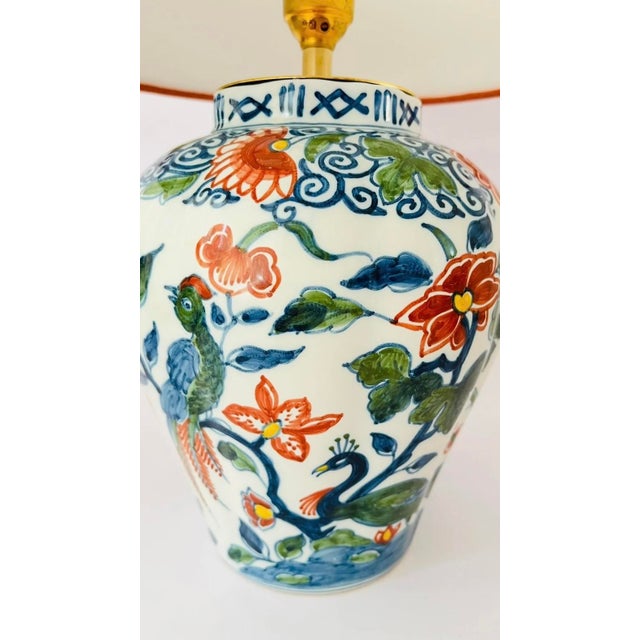 An early 20th century table lamp made from a rare antique lidded vase by royal tichelaar makkum. Decorated on an off white...
