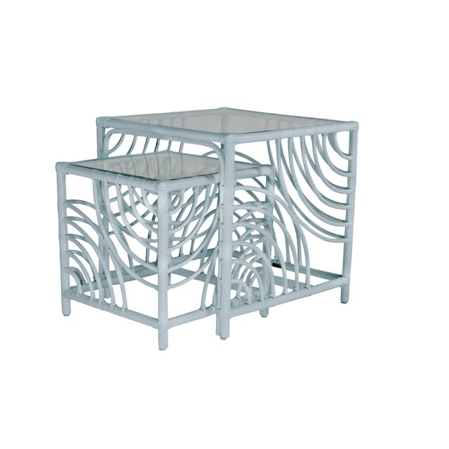 This functional and stylish two-piece nesting table features a Rattan frame with rawhide bindings and a clear, glass top....