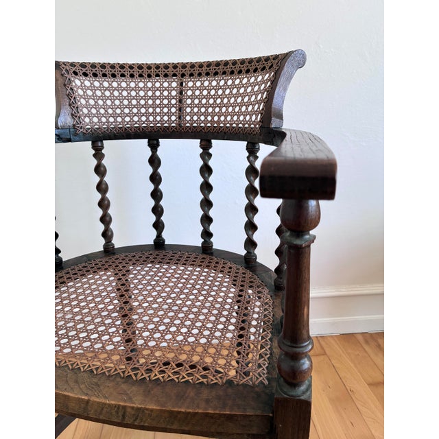 This Edwardian armchair dates from the early 20th century and is made of solid beech. The cane seat and backrest give it a...