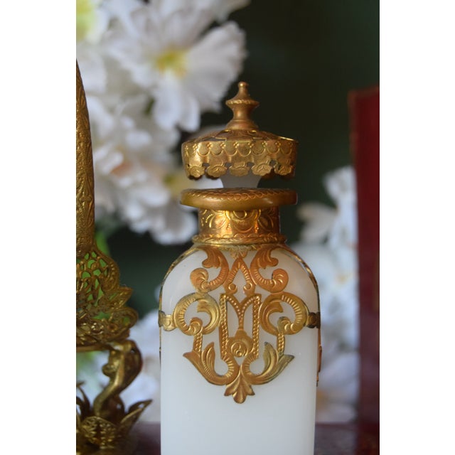 An exceptional 19th-century French perfume bottle crafted in luminous white opaline and set within an extraordinarily...