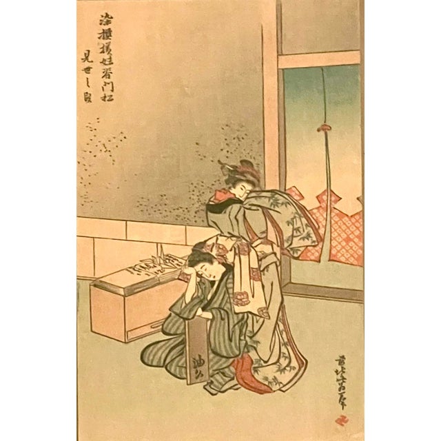 Framed Mid Century print of two Japanese ladies in their kimonos in front of a curtained window by Hokusai. They attempt...