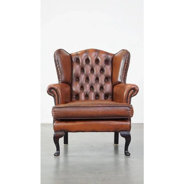 Offered is this very beautiful, stately, cowhide leather chesterfield ear chair with elegant legs in a fine brown color....