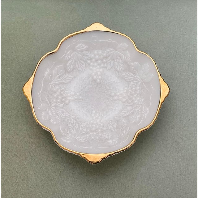 A classic footed milk glass gilt edge decorative bowl in a textured vineyard pattern. Ships within 1-2 days using USPS....