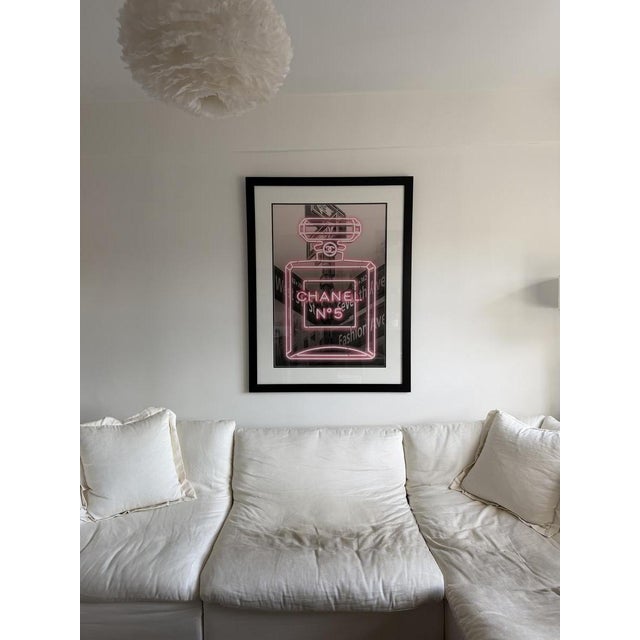 High-impact framed print featuring a vibrant neon-style Chanel No. 5 bottle. Purchased from a boutique design store in...