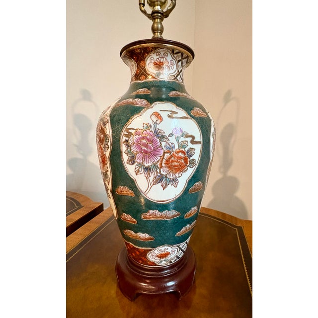 These lamps feature a dark green crackle-glaze finish on a porcelain body, decorated with hand-painted floral motifs, and...
