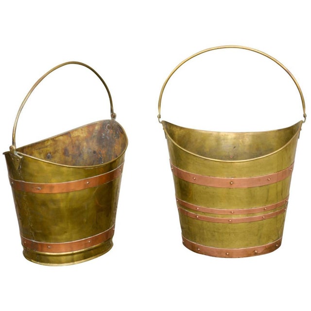 An English oval brass bucket with handle from the early 20th century. The rim of the brass bucket is curved on two sides...