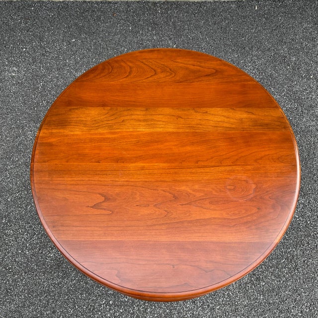 A late 20th century Pennsylvania House Traditional solid cherry round side table having a pedestal base and faux bamboo...
