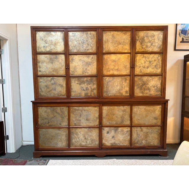 Design Plus Gallery presents a Two Piece Teak Wood Cabinet of Grand Proportions. The cabinet is framed and made of teak...