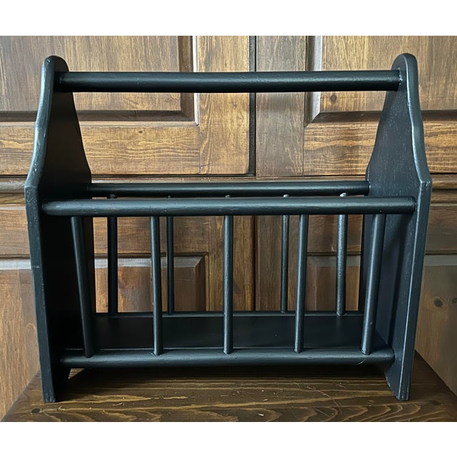 Vintage mid 20th Century wooden spindle style magazine rack. It has a matte black finish perfect for a Primitive or...