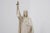 This devotional plaster statue depicts christ the king, standing with one hand raised in blessing and the other pointing...