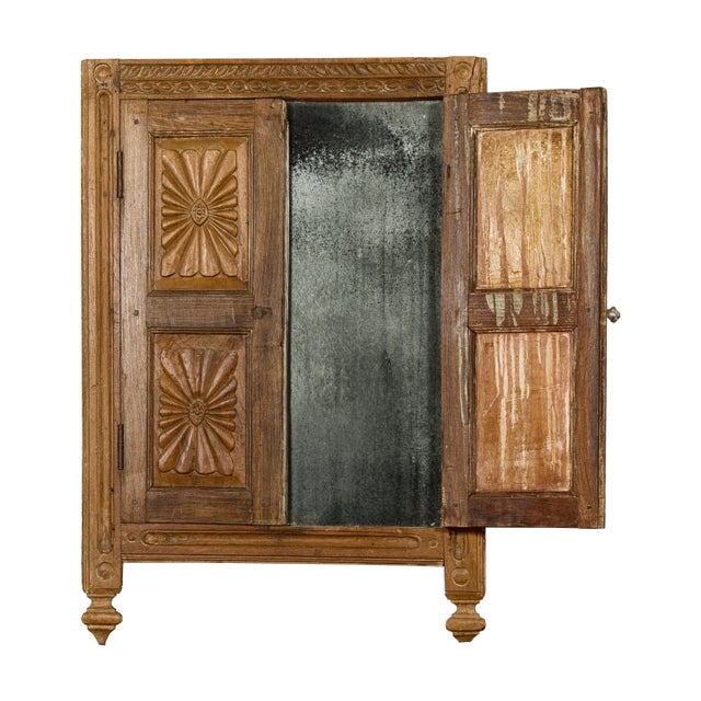 An antique Indian carved wooden window retrofitted with a smoky heavily antiqued mirror. This antique Indian carved wooden...
