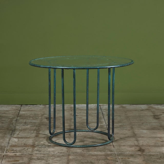 A patio dining table in patinated bronze designed by Walter Lamb and produced by Brown Jordan. The round frame is has...