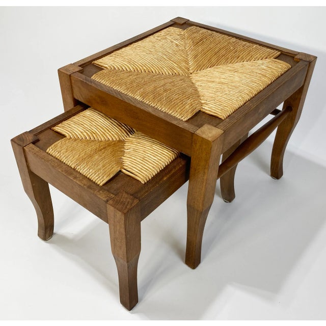 Vintage pair of wood stools with woven rush tops. Smaller stool measures 14.5"W x 10"L x 10"H. Nestles perfectly into...