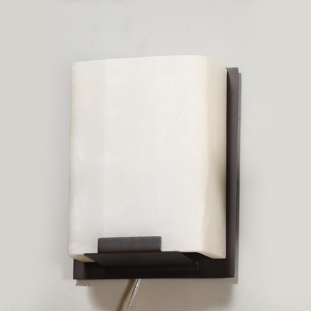 This elegant Pair of Modernist Alabaster & Oil-Rubbed Bronze Wall Sconces originated in the United States, 20th Century....