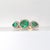 Elegant Three-Stone Emerald and Diamond Ring. This exquisite ring is crafted in 14k yellow gold. The centerpiece features...