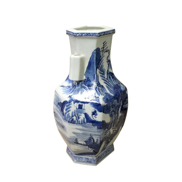 This is a Chinese decorative porcelain vase in Blue and White color finish. The theme is oriental mountain tree scenery...