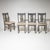 Set of four gray painted side chairs with upholstered seats. The central splat of each backrest is decorated with a...