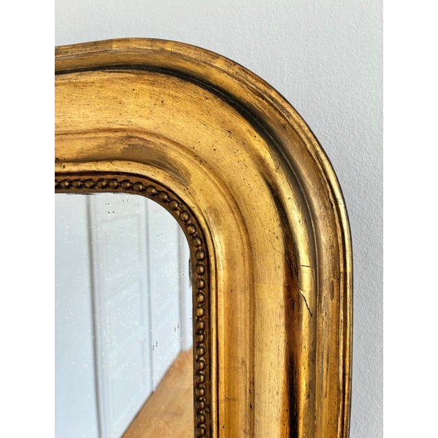 An antique French Louis Philippe mirror, dating to the late 19th century. This mirror has a giltwood frame with a warm...