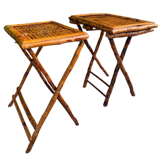 Vintage pair of folding burnt bamboo tray tables featuring a warm tortoise finish and handcrafted bamboo construction. The...
