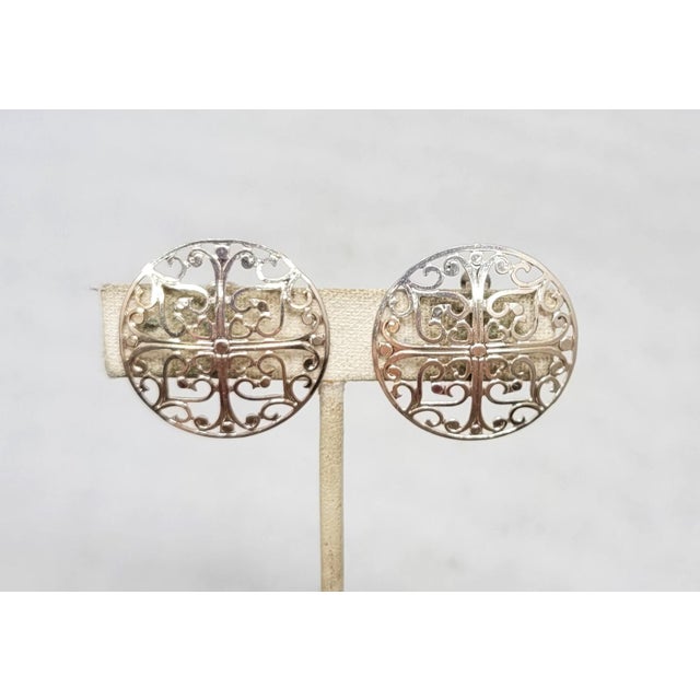 1970s rhodium plated round cut out design clip and screw back earrings. Marked "NAPIER." Measure: 1 1/8 inches across....