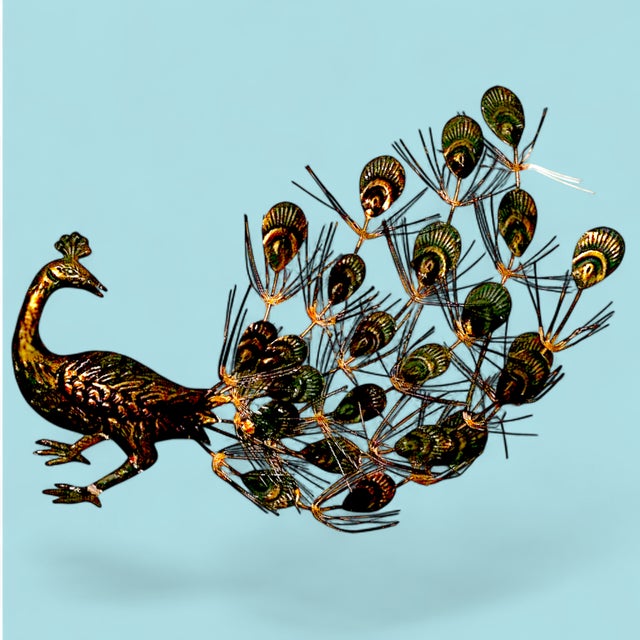 A pair of 1960's mid-century modern iconic decorative peacock wall hangings. They are made of a tin-like or aluminum metal...