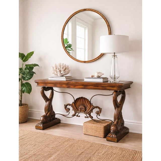 A striking Hollywood Regency console featuring sculptural dolphin supports and a dramatic shell motif, offering bold...