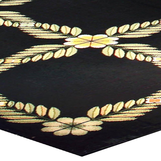 This antique Portuguese needlepoint rug from the 1940s radiates understated charm and graphic elegance, combining the...