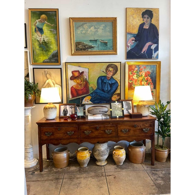 19th century Georgian walnut sideboard with three drawers and original brass pulls. Warmly patinated walnut with classic...