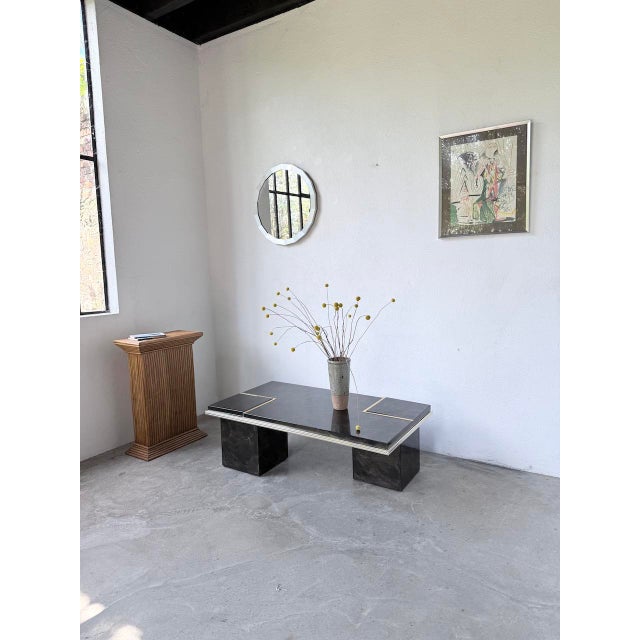 Vintage coffee table from the 1970s. it features a rectangular frame adorned with gilt metal details. Two openings are...
