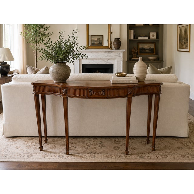 A finely crafted Maitland Smith console table in the English Adam style, distinguished by its serpentine front and richly...