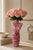 Striking vintage art glass vase sculpted in the form of a female torso, featuring luminous pink glass with white swirled...