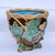 A richly glazed majolica jardinière, featuring deeply modeled leaves, vines, and berries in high relief. The naturalistic...
