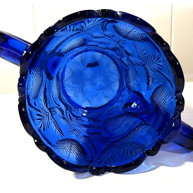 Add a brilliant pop of jewel-toned color to your tablescape with this striking vintage cobalt blue pressed glass vase....