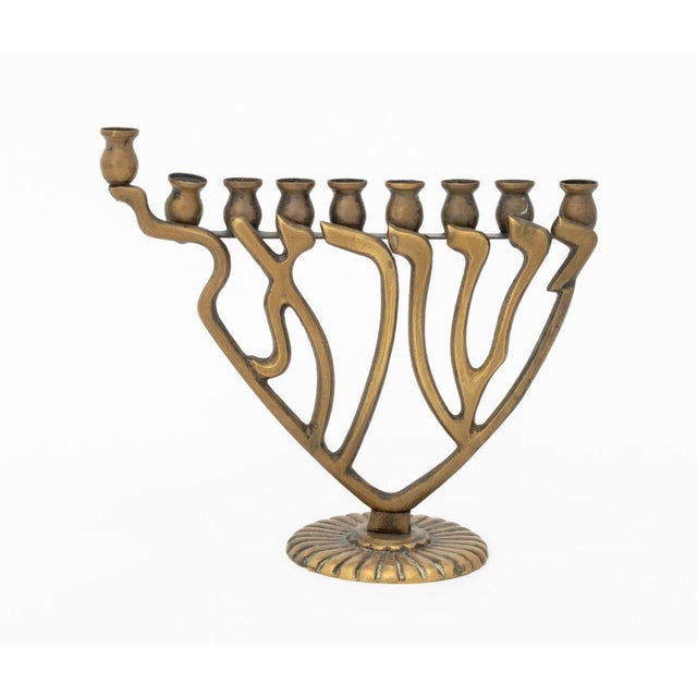 Collection of Three Judaica Brass Candelabra, comprising: a Hebrew character form menorah, a Lion of Judah motif menorah...
