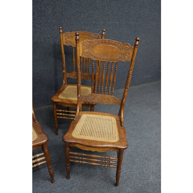 Set of four Larkin “No. 1” press back side chairs in quarter sawn oak. Each chair features an ornately carved pressed back...