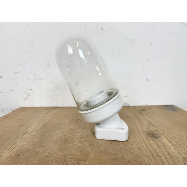 Vintage industrial wall light made in former Czechoslovakia during the 1960s. It features a white porcelain wall mounting...