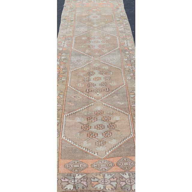 Measures: 3'6"X12'0" Vintage Turkish Oushak Runner with Muted Earth Tones and Soft Pastel Accents 3'6"x12'0". Antique...