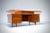 A large symmetrical desk by Silvio Cavatorta in solid walnut with on both sides 3 drawers and in the middle a larger...