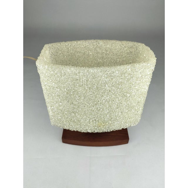 This 1960s table lamp, with its shade made of acrylic granules, produces a pleasantly warm, diffused light. The lamp base...