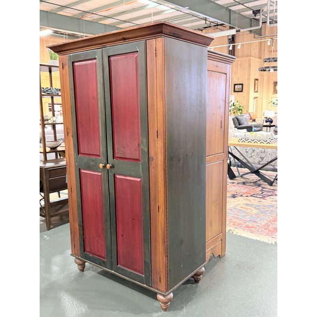 Solid wood media armoire designed by RomWeber featuring a classic cabinet form with paneled doors and turned feet. The...
