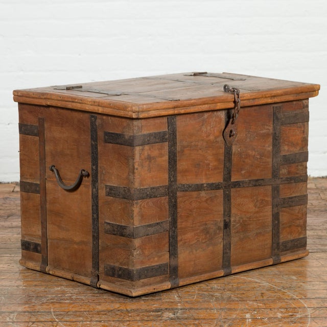 An Indian rustic wooden trunk from the 19th century with iron hardware and nicely weathered patina. Created in India...