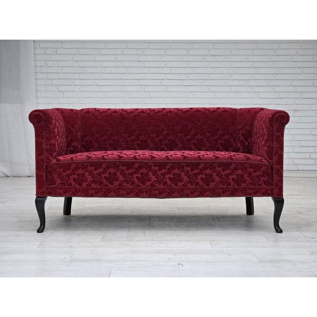 1950s, Danish 2-seater sofa. Cherry-red furniture velour, ash wood legs, springs in the seat. Sofa was reupholstered by...