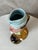 A charming, humorous earthenware pitcher made in the early 20th century by the Saint-Amand-les-Eaux factory. It depicts a...